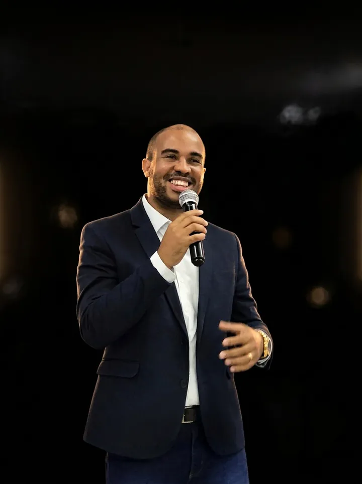 W. Carolino sorrindo com um microfone